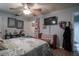 Comfortable bedroom with ceiling fan, wall-mounted television, and wooden floors at 616 Third Ave, Lady Lake, FL 32159