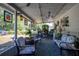 Inviting covered patio with outdoor seating, decorative lighting, and tranquil backyard views at 616 Third Ave, Lady Lake, FL 32159