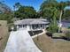 Charming single-story home with manicured lawn, landscaping, and long concrete driveway at 616 Third Ave, Lady Lake, FL 32159