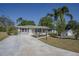 Inviting single-story home with a long driveway, well-maintained lawn, and appealing landscaping at 616 Third Ave, Lady Lake, FL 32159