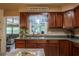 Well-lit kitchen showcases wood cabinets, stainless steel sink, and modern appliances at 616 Third Ave, Lady Lake, FL 32159