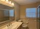 Well-lit bathroom with a vanity, mirror, and tiled walls at 619 W Seminole Ave, Eustis, FL 32726