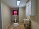 Bright laundry room with a utility sink, cabinets, and ample floor space at 619 W Seminole Ave, Eustis, FL 32726