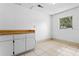 Unfinished basement area with tile flooring, window for natural light and white storage cabinets at 6808 Fern Cir, Leesburg, FL 34748