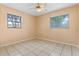 This bedroom features neutral walls, tiled flooring and two windows to provide natural light at 6808 Fern Cir, Leesburg, FL 34748