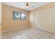 Bedroom with tiled flooring, ceiling fan, a window for natural light and a double-door closet at 6808 Fern Cir, Leesburg, FL 34748
