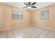 Cozy bedroom with tile flooring, neutral walls, and two windows for natural light at 6808 Fern Cir, Leesburg, FL 34748