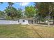 Charming single-story home with a well-maintained lawn, white picket fence, and mature shade trees at 6808 Fern Cir, Leesburg, FL 34748