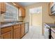 Well-lit kitchen featuring wood cabinets, a stainless steel sink, and tile flooring at 6808 Fern Cir, Leesburg, FL 34748