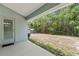 View from covered patio of a private backyard with lush greenery and a shed at 704 Chelsea Ave, Fruitland Park, FL 34731