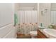 Well-lit bathroom showcasing a floral shower curtain, light walls, and modern finishes at 704 Chelsea Ave, Fruitland Park, FL 34731