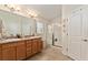 Bright bathroom featuring a double sink vanity with a granite countertop and a glass-enclosed shower at 704 Chelsea Ave, Fruitland Park, FL 34731
