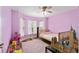 Lilac bedroom with a crib and a pink rug, filled with toys at 704 Chelsea Ave, Fruitland Park, FL 34731