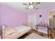 Lavender bedroom featuring laminate wood floors, pink accents, and modern decor at 704 Chelsea Ave, Fruitland Park, FL 34731