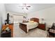 Comfortable bedroom features neutral carpet, ceiling fan, and warm wood furniture at 704 Chelsea Ave, Fruitland Park, FL 34731