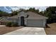 Charming single-story home with neutral paint, arched entryway, and a spacious two-car garage at 704 Chelsea Ave, Fruitland Park, FL 34731