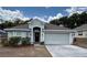 Charming single-story home featuring a two-car garage, neutral paint, and a well-manicured front lawn at 704 Chelsea Ave, Fruitland Park, FL 34731
