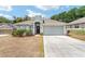 Charming single-story home with a well-manicured front yard, a two-car garage, and a welcoming entrance at 704 Chelsea Ave, Fruitland Park, FL 34731
