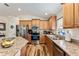 Bright kitchen featuring stainless steel appliances, wood cabinetry, and granite countertops at 704 Chelsea Ave, Fruitland Park, FL 34731