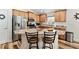 Modern kitchen featuring a center island with seating, stainless steel appliances, and wood cabinetry at 704 Chelsea Ave, Fruitland Park, FL 34731