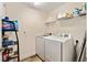 Laundry room featuring modern appliances and shelving for ample storage at 704 Chelsea Ave, Fruitland Park, FL 34731