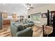 A cozy living room with wood flooring and a ceiling fan, seamlessly connected to the kitchen at 704 Chelsea Ave, Fruitland Park, FL 34731