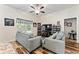 Inviting living room featuring natural light, ceiling fan, and wood-look flooring for a cozy feel at 704 Chelsea Ave, Fruitland Park, FL 34731