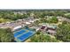 Community aerial view featuring tennis courts, a clubhouse, and tree-lined streets in a well-maintained neighborhood at 705 Grand Vista Trl, Leesburg, FL 34748