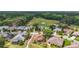 An aerial view of a home in a well-maintained community with a nearby golf course and tree lined streets at 705 Grand Vista Trl, Leesburg, FL 34748
