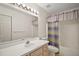Bathroom features a single sink, white cabinets, toilet, and bathtub with shower at 705 Grand Vista Trl, Leesburg, FL 34748
