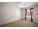 Carpeted bedroom featuring a ceiling fan and large window with burgundy curtains at 705 Grand Vista Trl, Leesburg, FL 34748