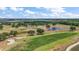 Expansive golf course with mature trees and a water feature; golf cart visible at 705 Grand Vista Trl, Leesburg, FL 34748