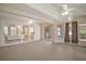 Spacious carpeted sunroom with ceiling fans and sliding glass doors leading to other rooms at 705 Grand Vista Trl, Leesburg, FL 34748