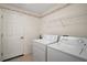 Laundry room features a full-size washer and dryer and extra storage on a shelf at 705 Grand Vista Trl, Leesburg, FL 34748