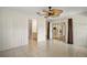 Bright living room featuring neutral tile floors, a decorative ceiling fan, and sliding glass doors to lanai at 705 Grand Vista Trl, Leesburg, FL 34748
