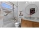 Bright bathroom featuring modern fixtures, white and gold patterned tiling, and tub with shower at 722 Barefoot Bay Loop, Groveland, FL 34736