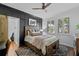 Bedroom showcasing a wooden bed frame, ceiling fan, and black accent wall at 722 Barefoot Bay Loop, Groveland, FL 34736