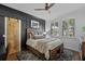 Bedroom showcasing a wooden bed frame, ceiling fan, and black accent wall with a sliding door at 722 Barefoot Bay Loop, Groveland, FL 34736