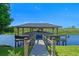 Picturesque boat dock featuring a covered boat lift, perfect for boating and enjoying waterfront living at 722 Barefoot Bay Loop, Groveland, FL 34736