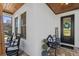 Inviting front porch featuring a decorative wreath, a welcome mat, and comfortable rocking chair seating at 722 Barefoot Bay Loop, Groveland, FL 34736