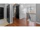 Hallway view features a sliding black door to a closet, a decorative chandelier, and wood floors at 722 Barefoot Bay Loop, Groveland, FL 34736