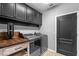 Efficient laundry room features gray appliances, dark wood cabinets, and wooden countertop at 722 Barefoot Bay Loop, Groveland, FL 34736