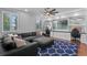 Bright living room with built-in shelves, large sectional, and hardwood floors at 722 Barefoot Bay Loop, Groveland, FL 34736