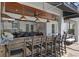 Luxurious outdoor kitchen and bar area with wood ceiling and comfortable seating for entertaining at 722 Barefoot Bay Loop, Groveland, FL 34736
