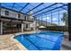Stunning screened-in pool area with lounge chairs and an outdoor bar, perfect for relaxation and entertainment at 722 Barefoot Bay Loop, Groveland, FL 34736