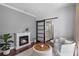 Cozy sitting room with a fireplace, plush chairs, and sliding barn door to bathroom at 722 Barefoot Bay Loop, Groveland, FL 34736