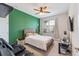 Bedroom with a large bed, green accent wall, ceiling fan, and a window at 743 Brooks Field Drive Dr, Winter Garden, FL 34787