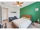 Bedroom featuring a green accent wall, ceiling fan, and a leather futon couch at 743 Brooks Field Drive Dr, Winter Garden, FL 34787