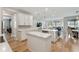Open-concept kitchen with island, white cabinets, and seamless flow into the living and dining areas at 743 Brooks Field Drive Dr, Winter Garden, FL 34787