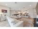 Open-concept living room with a sectional sofa, wood floors, and view into the modern, white kitchen at 743 Brooks Field Drive Dr, Winter Garden, FL 34787